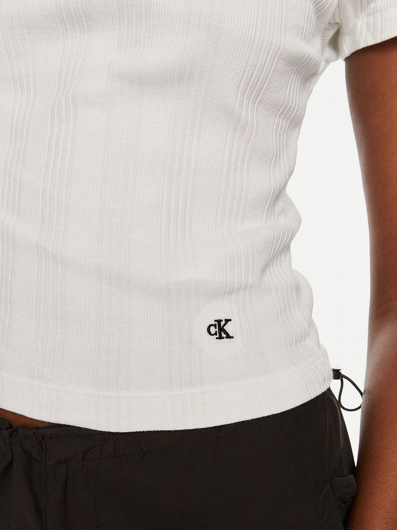 Modelo-con-polera-blanca-de-cuello-corto-Calvin-Klein-y-pantalones-negros