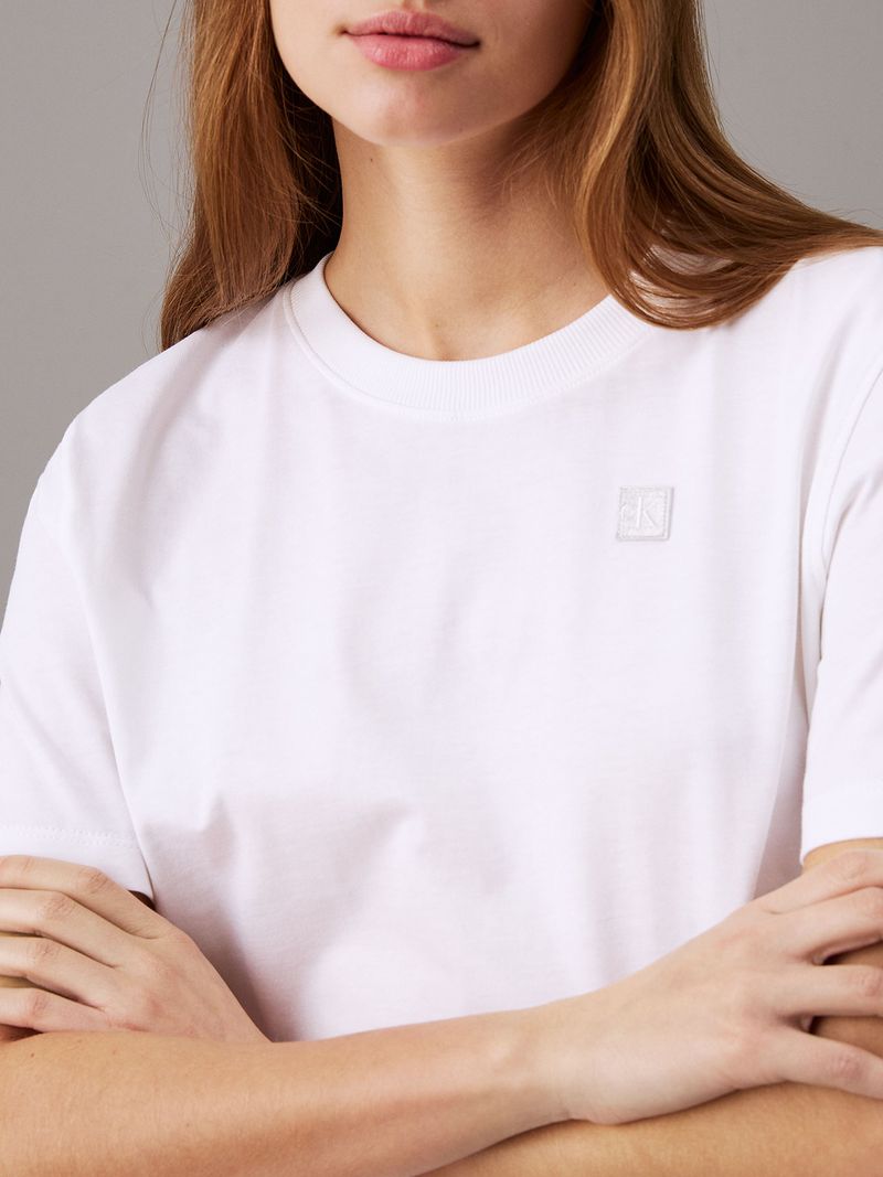 Modelo-con-polera-blanca-Calvin-Klein-y-jeans-azules