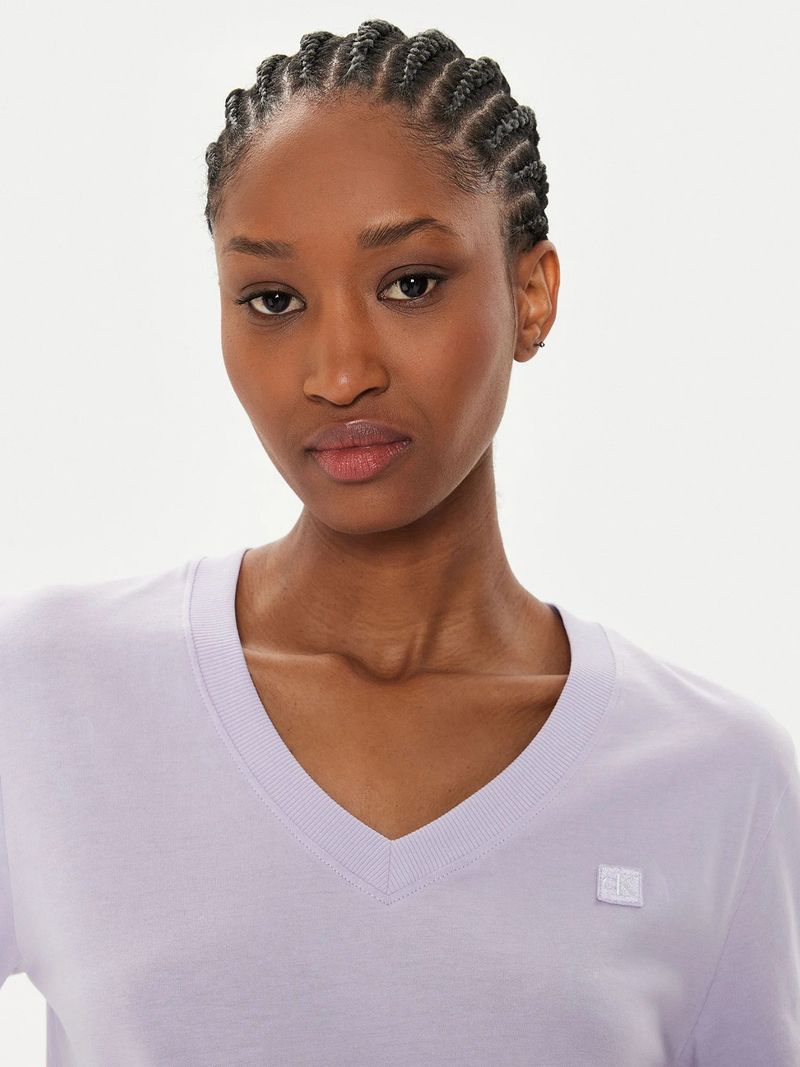 Modelo-con-polera-lila-Calvin-Klein-de-cuello-en-V-y-jeans-azules