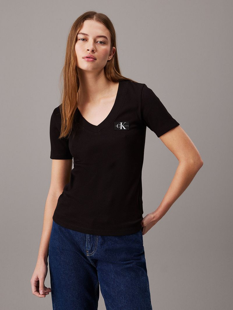 Modelo-con-polera-negra-Calvin-Klein-de-cuello-en-V-y-jeans-azules