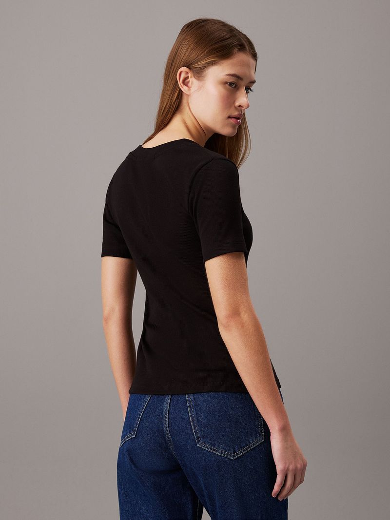 Modelo-con-polera-negra-Calvin-Klein-de-cuello-en-V-y-jeans-azules
