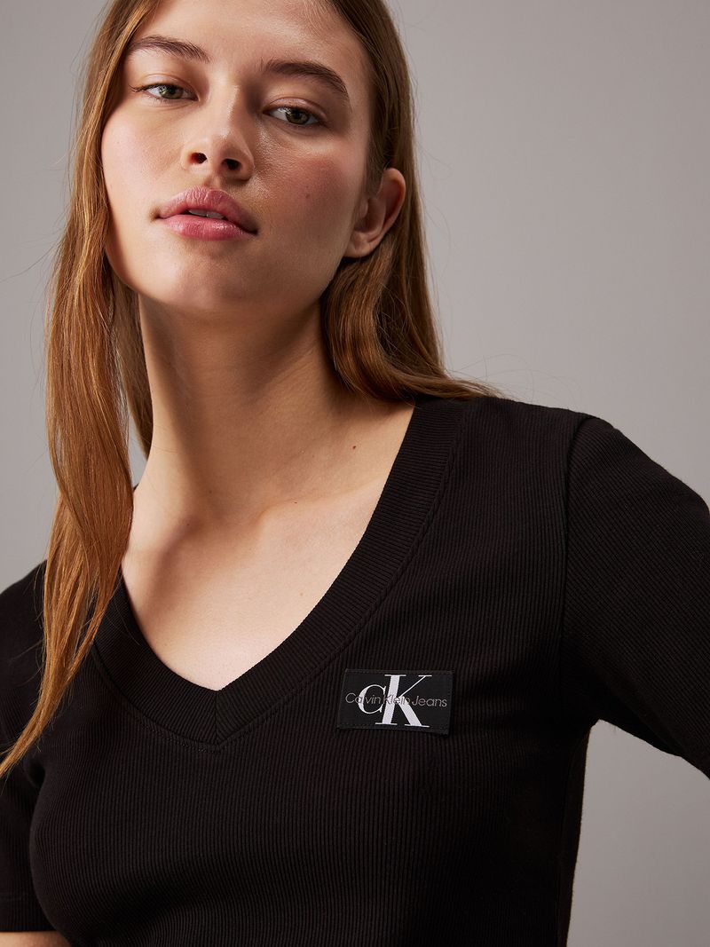 Modelo-con-polera-negra-Calvin-Klein-de-cuello-en-V-y-jeans-azules