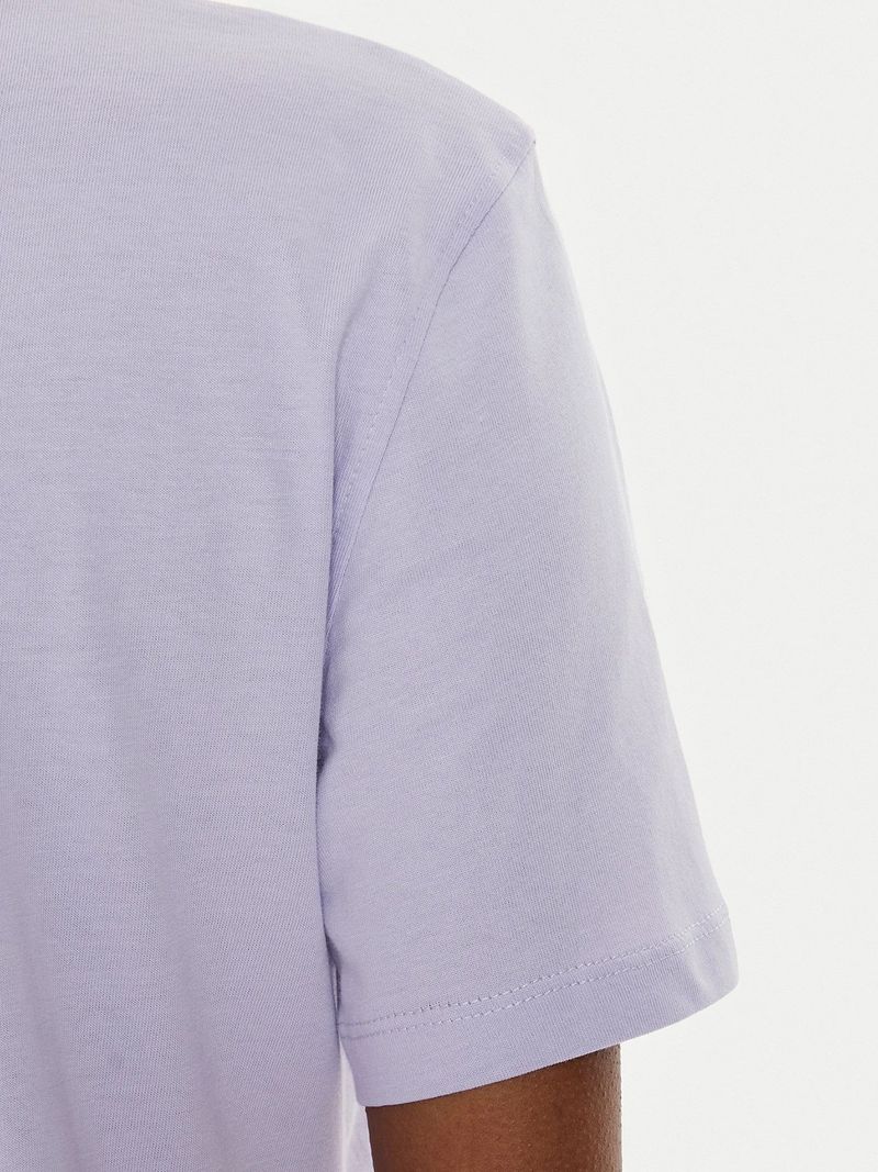 Modelo-con-polera-lila-Calvin-Klein-y-jeans-azules