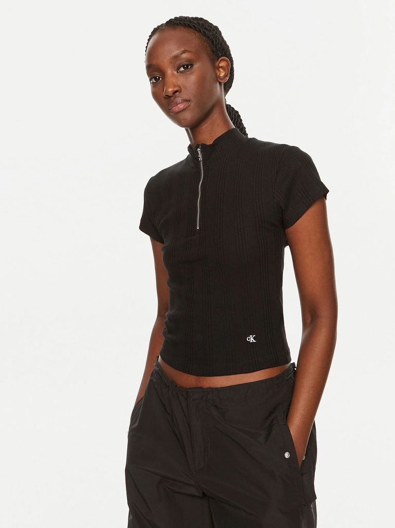 Modelo-con-polera-negra-Calvin-Klein-de-media-cremallera-y-pantalones-oscuros