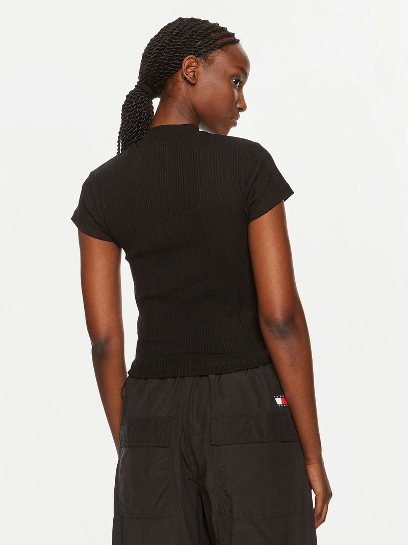 Modelo-con-polera-negra-Calvin-Klein-de-media-cremallera-y-pantalones-oscuros