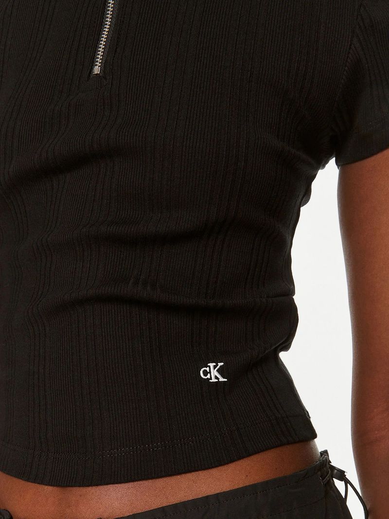 Modelo-con-polera-negra-Calvin-Klein-de-media-cremallera-y-pantalones-oscuros