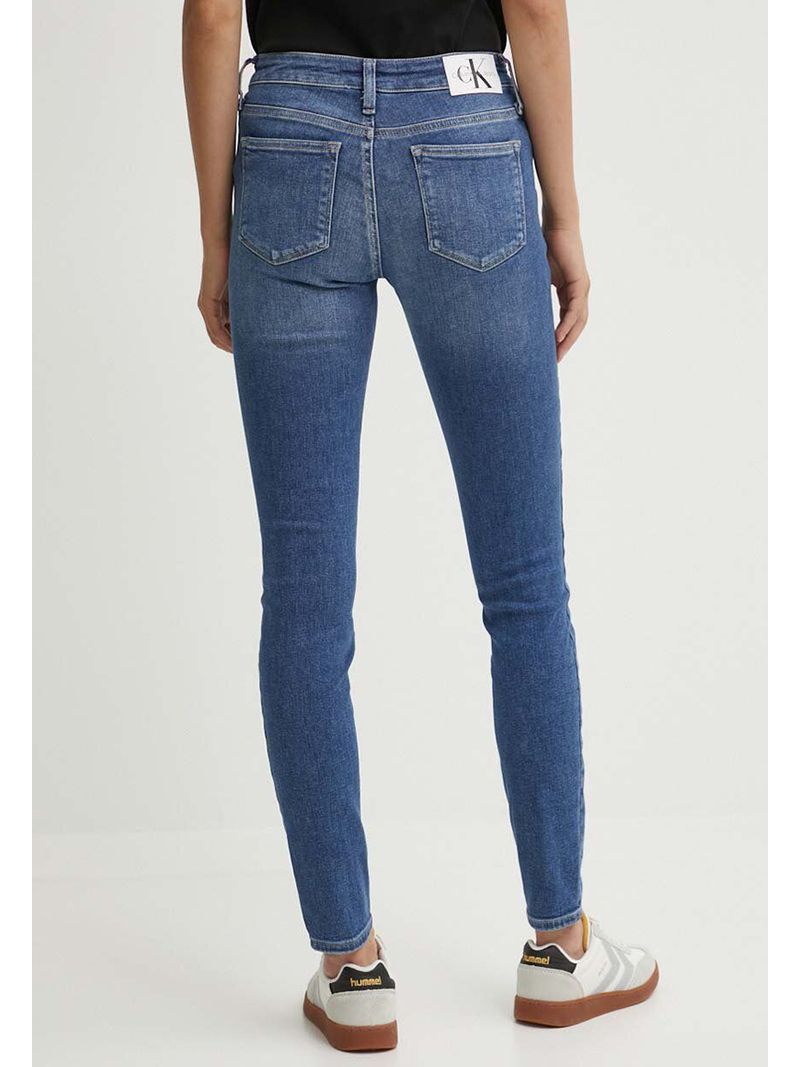 Modelo-con-jeans-skinny-azules-Calvin-Klein-y-zapatillas-grises