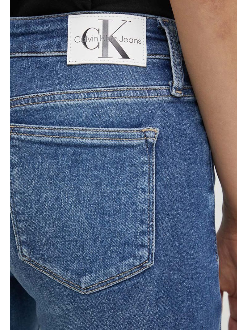 Modelo-con-jeans-skinny-azules-Calvin-Klein-y-zapatillas-grises