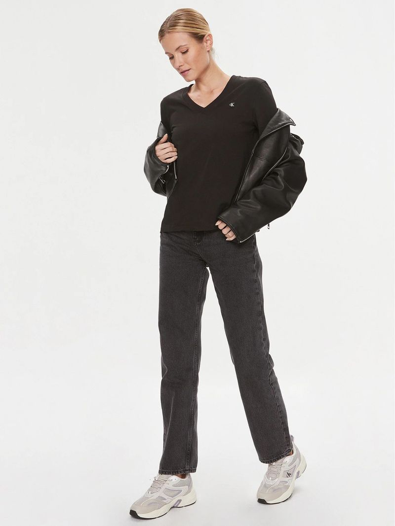 Modelo-con-polera-negra-Calvin-Klein-de-cuello-en-V-y-jeans-oscuros