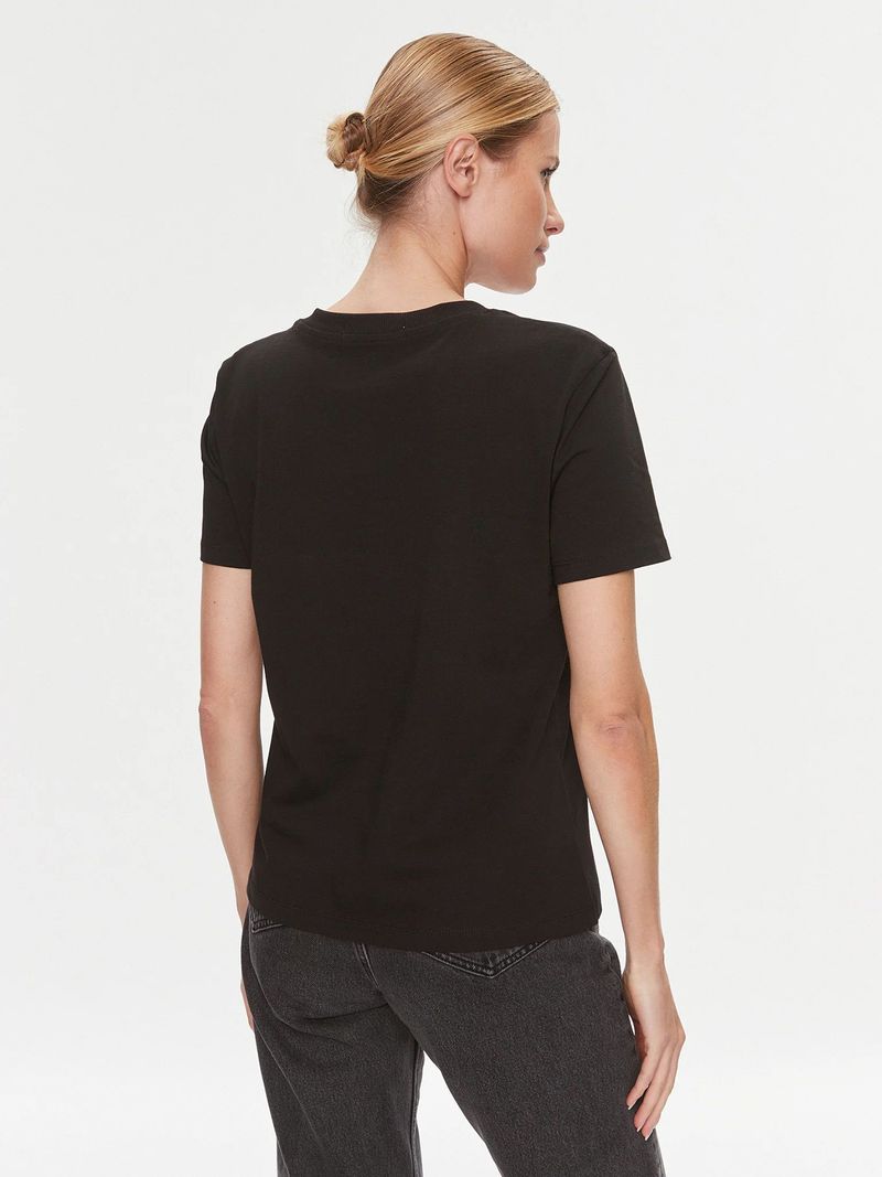 Modelo-con-polera-negra-Calvin-Klein-de-cuello-en-V-y-jeans-oscuros