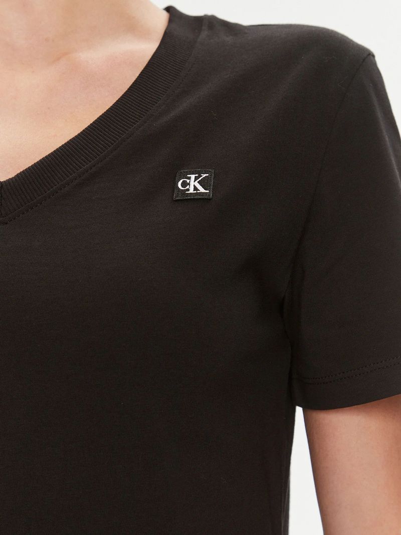 Modelo-con-polera-negra-Calvin-Klein-de-cuello-en-V-y-jeans-oscuros