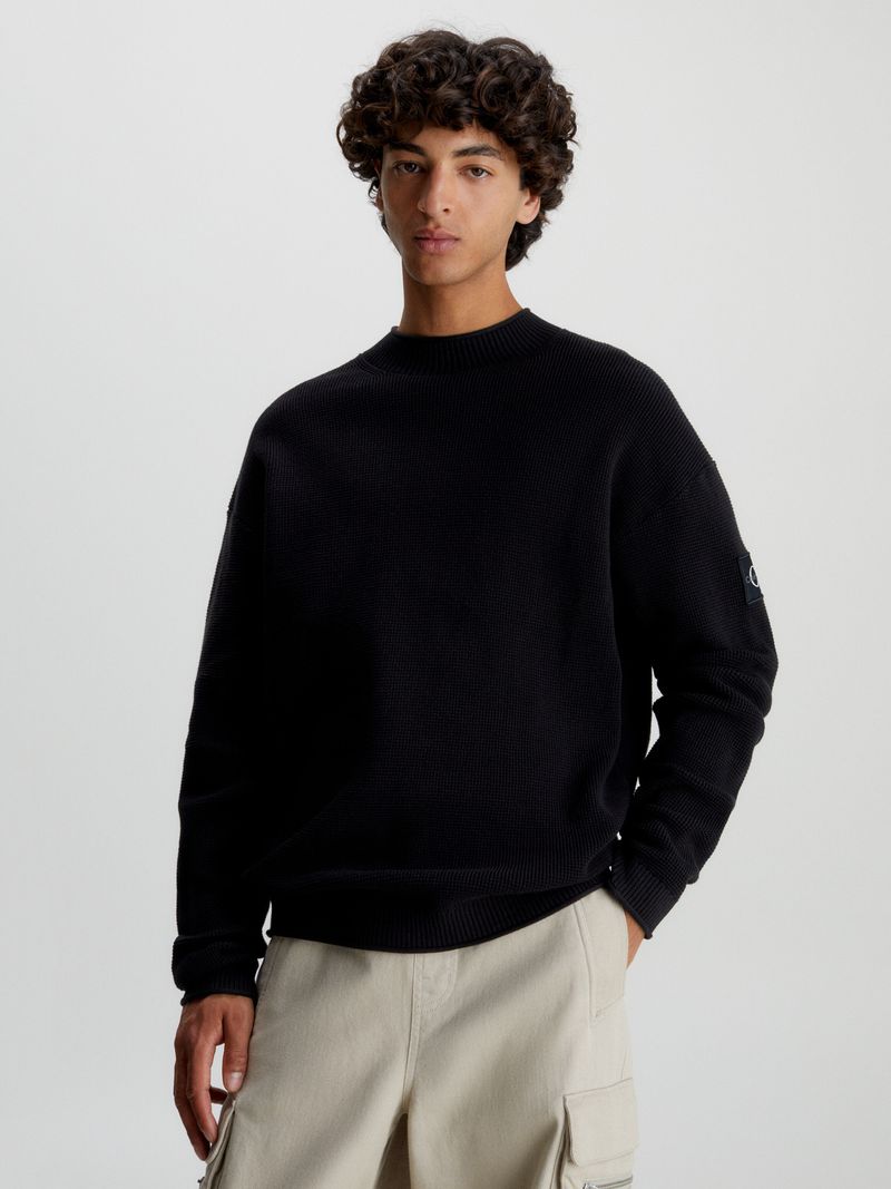 Modelo-con-sweater-negro-Calvin-Klein-y-pantalones-cargo-beige