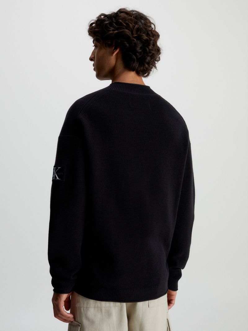 Modelo-con-sweater-negro-Calvin-Klein-y-pantalones-cargo-beige