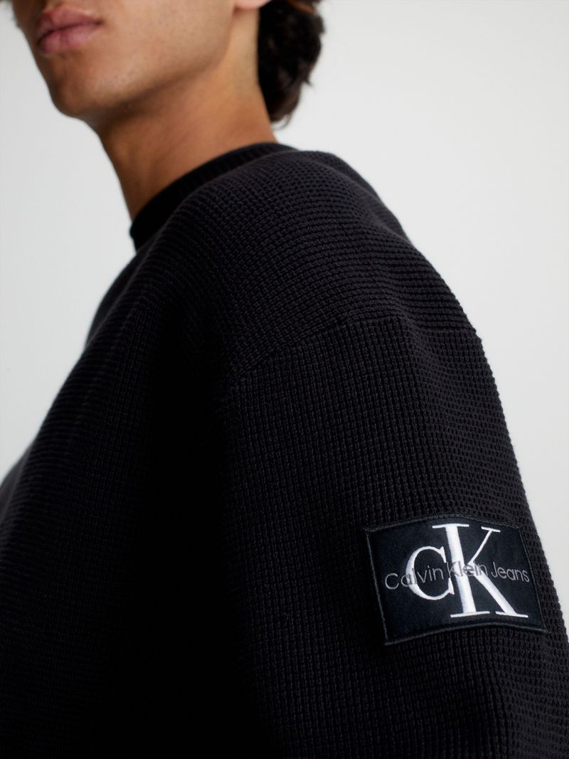 Modelo-con-sweater-negro-Calvin-Klein-y-pantalones-cargo-beige