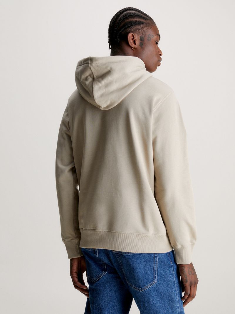 Modelo-con-poleron-beige-Calvin-Klein-Jeans-y-jeans-azules