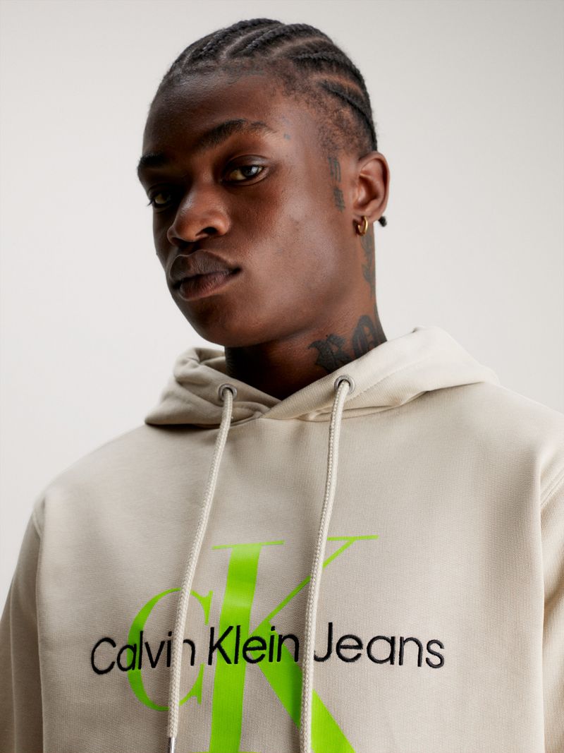Modelo-con-poleron-beige-Calvin-Klein-Jeans-y-jeans-azules