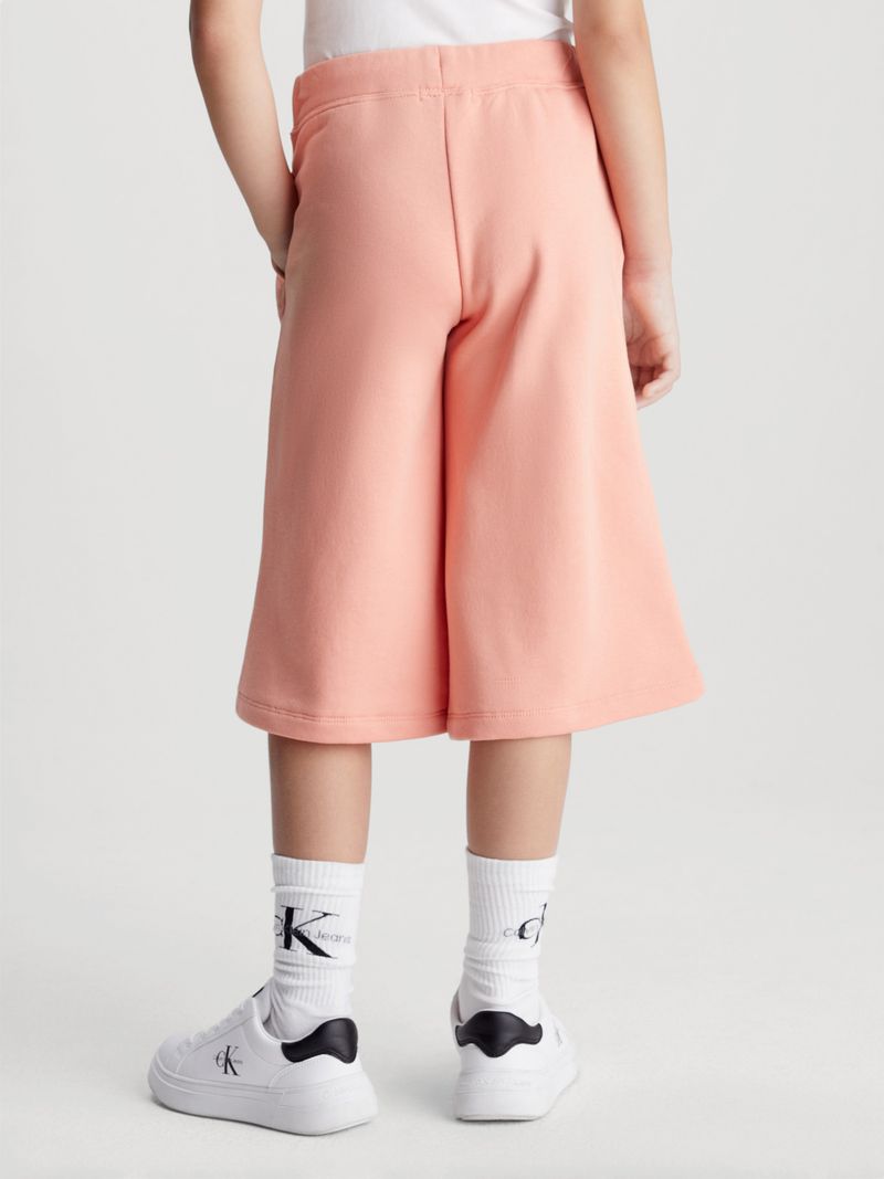 Modelo-con-bermudas-rosadas-Calvin-Klein-y-zapatillas-blancas