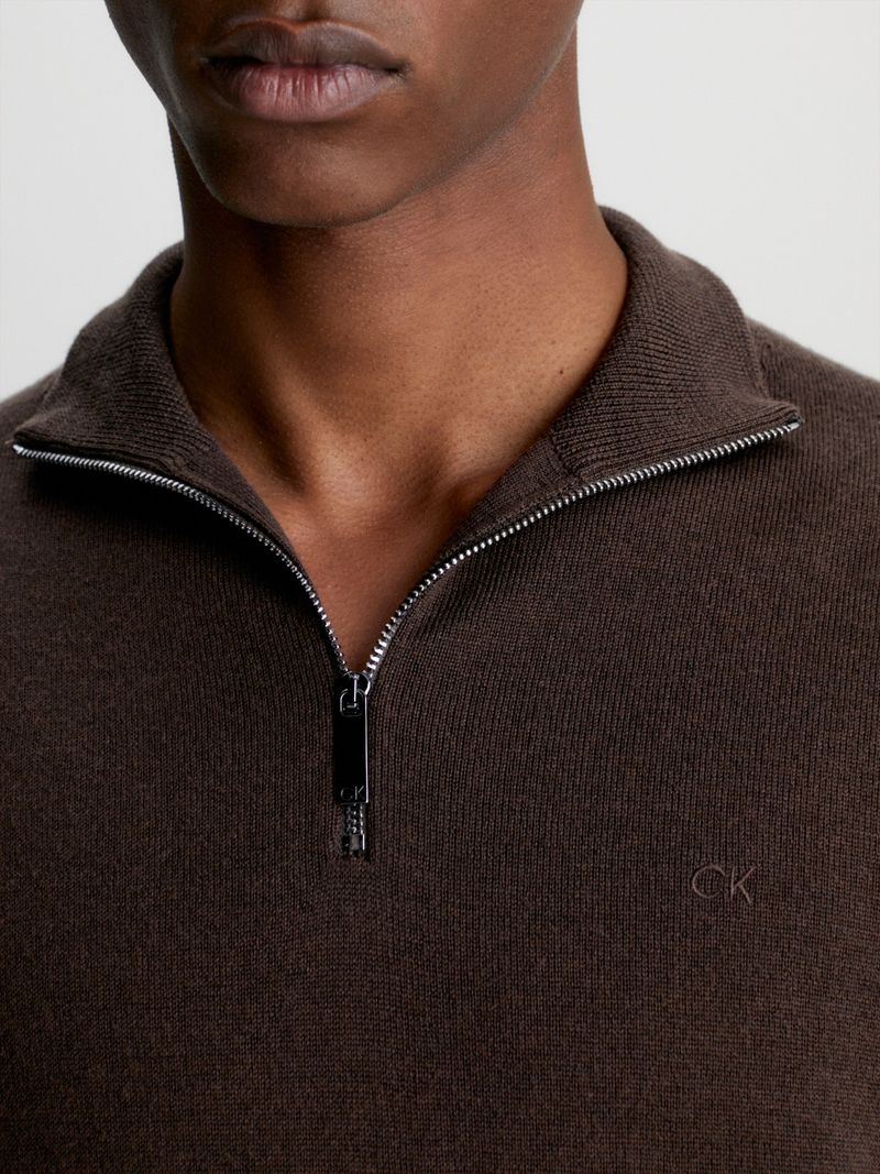 Modelo-con-sweater-cafe-de-cierre-medio-Calvin-Klein-y-pantalones-negros