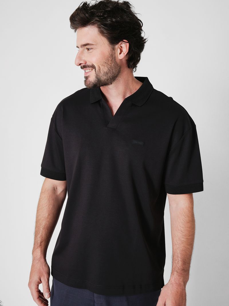 Modelo-con-polera-negra-cuello-en-V-Calvin-Klein-y-pantalones-oscuros