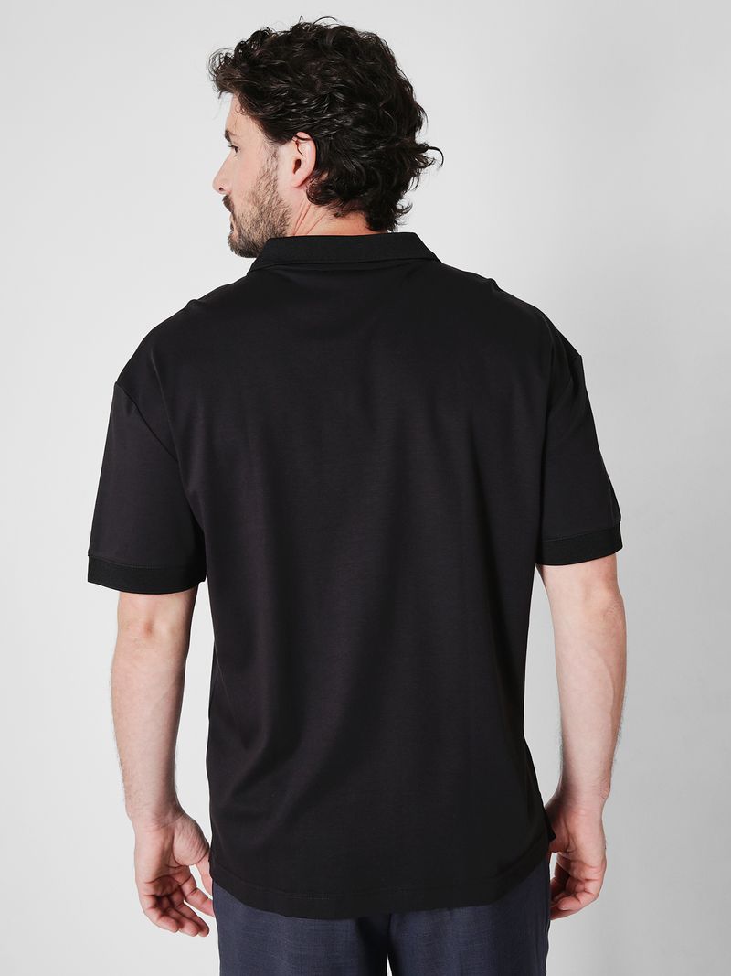 Modelo-con-polera-negra-cuello-en-V-Calvin-Klein-y-pantalones-oscuros
