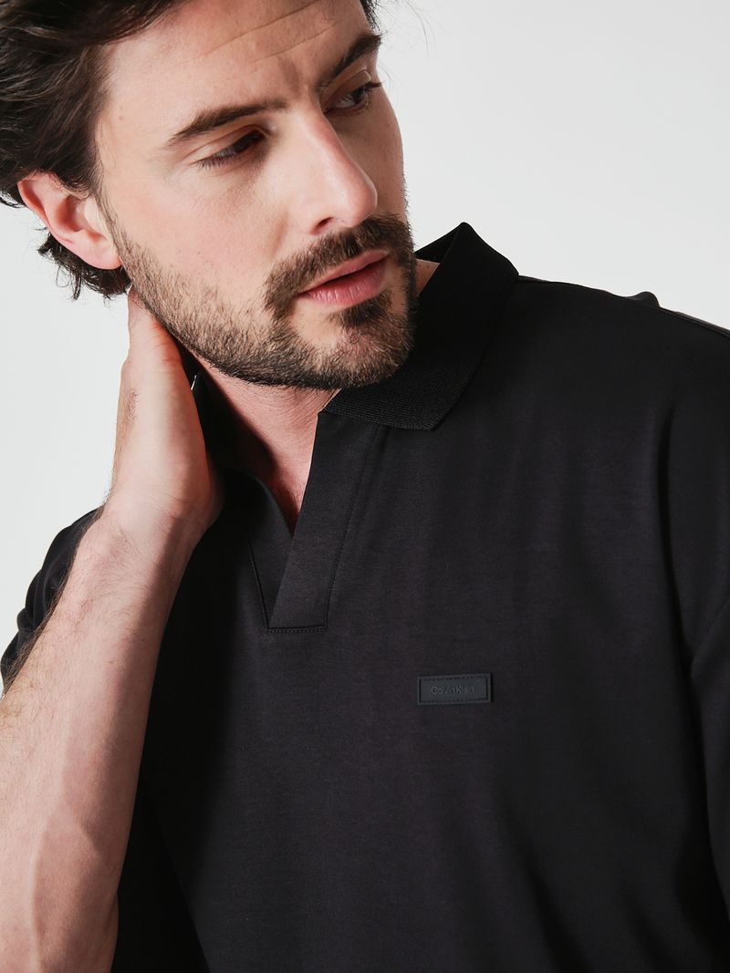 Modelo-con-polera-negra-cuello-en-V-Calvin-Klein-y-pantalones-oscuros