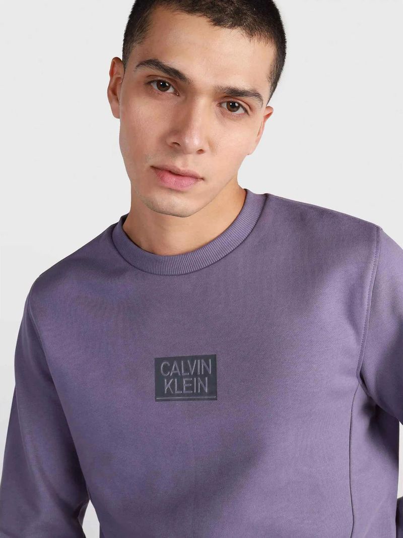 Modelo-con-poleron-lila-Calvin-Klein-y-pantalones-oscuros