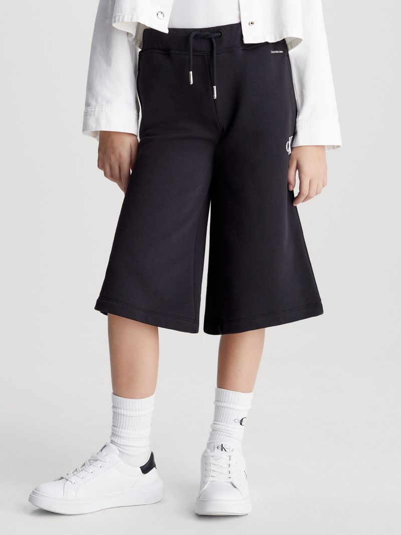 Modelo-con-bermudas-negras-Calvin-Klein-y-zapatillas-blancas