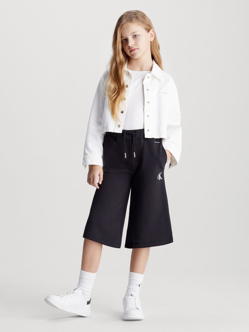 Modelo-con-bermudas-negras-Calvin-Klein-y-zapatillas-blancas