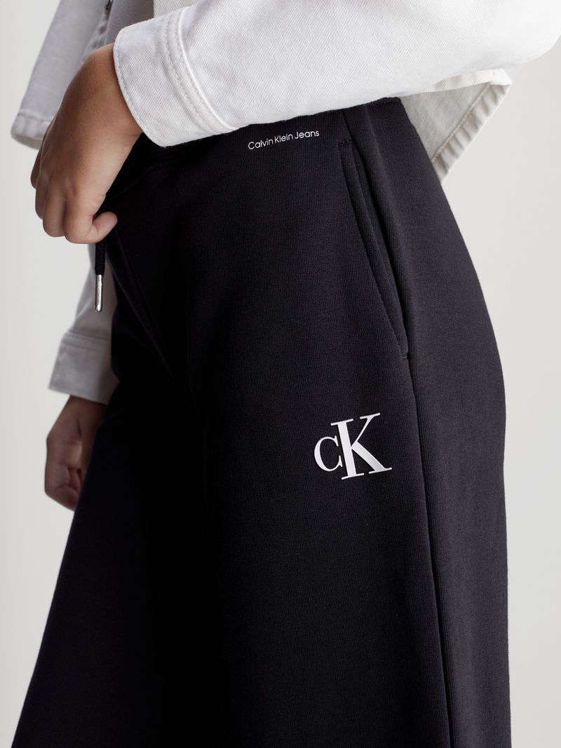 Modelo-con-bermudas-negras-Calvin-Klein-y-zapatillas-blancas