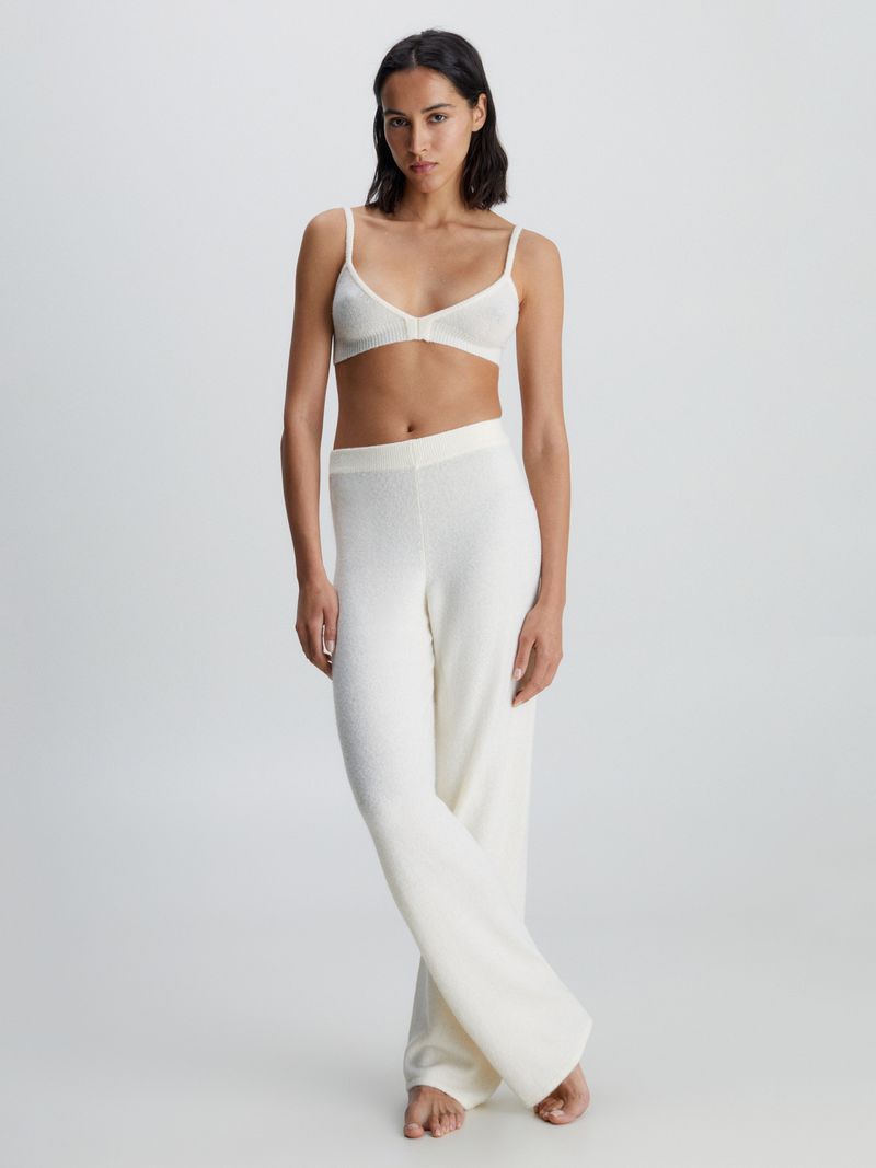 Modelo-luciendo-pantalon-de-lana-blanco-Calvin-Klein-de-corte-recto-y-cintura-elastica.